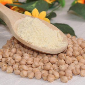 cuchara de madera conteniente harina precocida de garbanzos. Alrededor, varios garbanzos enteros como decoración.