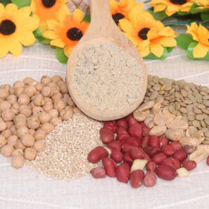 Al centro, cuchara de madera con harina fmix. Alrededor, decoración con sus ingredientes y flores amarillas.