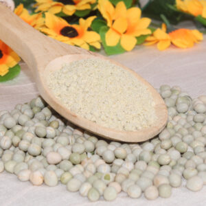 Al centro, cuchara de madera conteniente harina de arvejas precocidas. Decoración compuesta por arvejas enteras, flores amarillas y hojas.