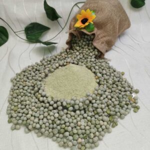 Al centro montañita de harina precocida de arvejas. Alrededor de ella, arvejas enteras esparcidas como decoración. Al fondo, bolsa de tela decorada con flor y hojas.